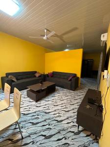 a living room with couches and a yellow wall at Archelux Developments in Bawalishi