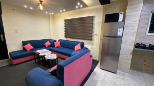 a living room with a blue couch and a table at عجلون in Ajloun