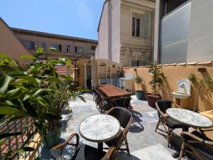 an outdoor patio with tables and chairs and plants at Dieu Bé Nice in Nice