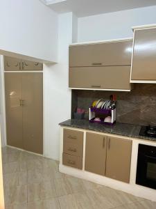 a kitchen with white cabinets and a counter top at Dar El corniche in Mahdia
