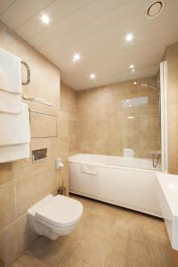 a bathroom with a toilet and a tub and a sink at MyApartments in Tallinn +27 photos