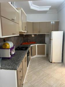 a kitchen with a white refrigerator and a counter top at Dar El corniche in Mahdia
