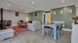 a kitchen and living room with a table and chairs at Roe Barn in Sherston
