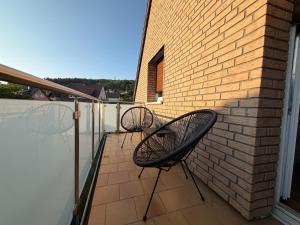 two chairs sitting on a balcony with a brick wall at Ferienwohnung Balkon Grupe in Stadtoldendorf