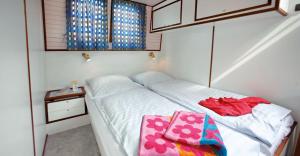 a small bedroom with a bed with two bags on it at Boats & Yachts at Zeuthen Marina by Kuhnle-Tours in Zeuthen +14 photos