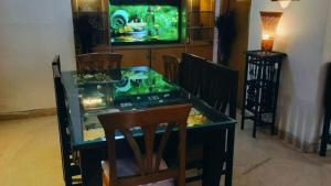 a dining room table with a fish tank on it at Dr Balis Bliss Homestay in New Delhi +14 photos