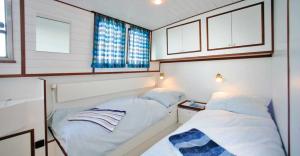 a small room with two beds and a window at Boats & Yachts at Zeuthen Marina by Kuhnle-Tours in Zeuthen
