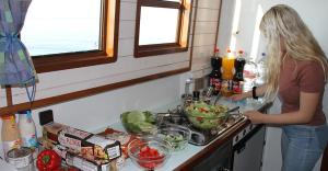 a woman standing in a kitchen preparing food at Boats & Yachts at Zeuthen Marina by Kuhnle-Tours in Zeuthen