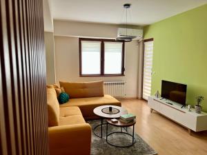 a living room with a couch and a tv at Urban Taft Stay Skopje-Modern Vodno View Suite with Private Parking in Taftalidze in Skopje