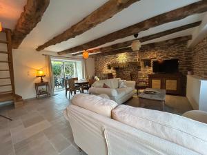 a living room with a white couch and a brick wall at La Maison de Gautro in Tréhorenteuc