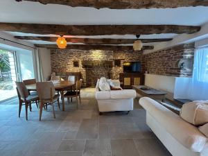 a living room with a table and a brick wall at La Maison de Gautro in Tréhorenteuc +17 photos