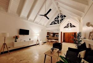 a living room with a ceiling fan and a table at Villa Arena Blanca in Punta Cana