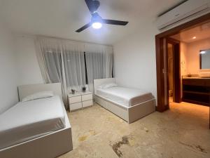 a bedroom with two beds and a ceiling fan at Villa Arena Blanca in Punta Cana