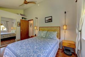 a bedroom with a bed with a blue comforter at Hale Ola Aina in Keaau