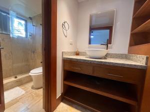 a bathroom with a sink and a toilet and a mirror at Villa Arena Blanca in Punta Cana
