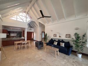 a living room with a blue couch and a table at Villa Arena Blanca in Punta Cana