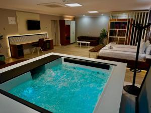 a large swimming pool in a room with a bedroom at Hotel Zouk Suite Spa in Alba Iulia