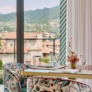 a table and chairs with a view of a balcony at Falkensteiner Resort Lake Garda in Salò