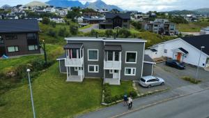 a house with a car parked in front of it at Cozy Lofoten Hideaway in Leknes