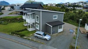 a small house with a car parked in front of it at Cozy Lofoten Hideaway in Leknes