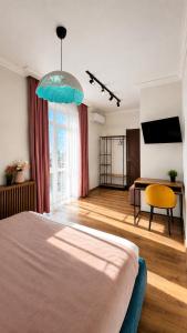 a bedroom with a bed and a desk and a television at Mountain View "Green Apartment" in Mukacheve +30 photos