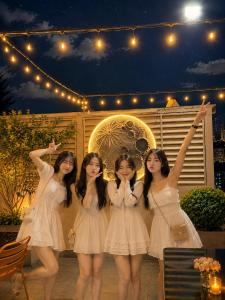 a group of girls in white dresses posing for a picture at Athena Hotel Huế in Hue