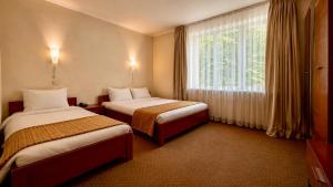 a hotel room with two beds and a window at Одеський дворик Hotel and Restaurant in Odesa +99 photos