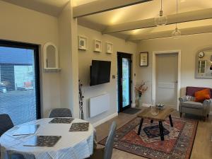 a living room with a table and a tv at Glassdrumman Stables in Ballynahinch
