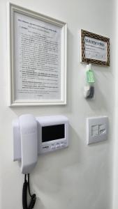 a television and a phone on a wall at Casa requinte estilo Ap próx Fema Unesp in Assis