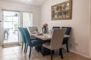 a dining room with a table and blue chairs at Port St Lucie Poolside Oasis in Port Saint Lucie