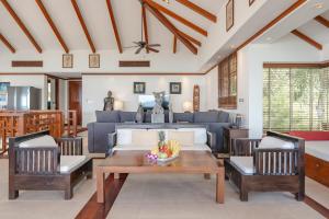 a living room with a couch and a table and chairs at Patong 4BR Seaview Villa with Infinity Pool in Patong Beach