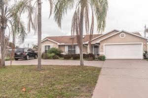 a house with palm trees in front of a driveway at Port St Lucie Poolside Oasis in Port Saint Lucie