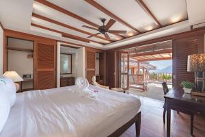 a bedroom with a large white bed and a desk at Patong 4BR Seaview Villa with Infinity Pool in Patong Beach