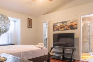 a bedroom with a bed and a flat screen tv at Port St Lucie Poolside Oasis in Port Saint Lucie