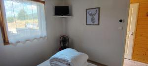 a room with a bed and a window and a television at Les Fermes du Lac - Appt 10A in Gérardmer