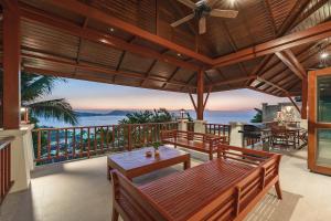 a patio with a table and chairs on a balcony at Patong 4BR Seaview Villa with Infinity Pool in Patong Beach