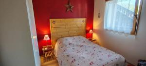 a small bedroom with a bed and red walls at Les Fermes du Lac - Appt 10A in Gérardmer