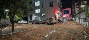 a dirt parking lot with cars parked in front of a building at Hotel Pooja Inn Pandharpur in Pandharpur