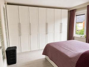 a bedroom with white cabinets and a bed at apartment 2 miles from Maastricht in Lanaken +7 photos