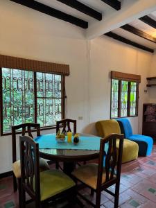 a living room with a table and chairs and a couch at Hospedaje Casa Renasiente Cali in Cali +21 photos