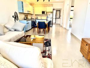 a living room with a couch and a kitchen at Gaia 2BR First Floor Apartment in El Dab‘a