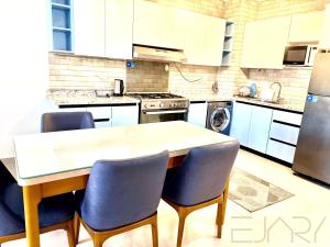a kitchen with a table and chairs in it at Gaia 2BR First Floor Apartment in El Dab‘a +2 photos
