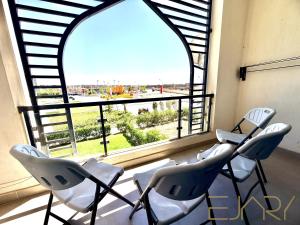 three chairs sitting in front of a large window at Gaia 2BR First Floor Apartment in El Dab‘a