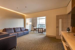 a living room with a blue couch and a table at K Hotel in Goiânia