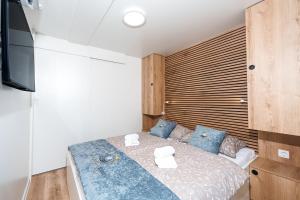 a bedroom with a bed with blue pillows and a television at Pearl Infinity Luxury Floating House in Novigrad Istria