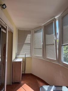 a room with windows and a refrigerator in it at Dunav View Residence - River View Free Parking in Belgrade