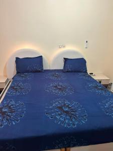 a blue bed with blue sheets and pillows at Tatkaba résidence in Conakry