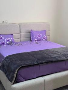 a bed with purple sheets and purple pillows at Tatkaba résidence in Conakry
