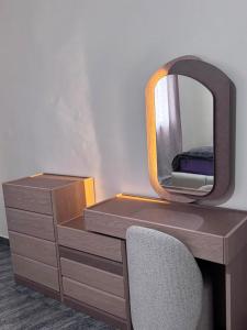 a desk with a mirror and a dresser with a chair at Tatkaba résidence in Conakry +3 photos