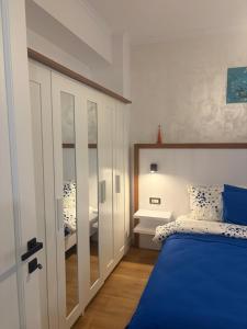 a bedroom with a blue bed and a mirror at Lili room in Focşani